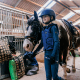Een jeugdlid van Ruitervereniging Rozenburg loopt trots met haar paard en het nieuwe zadel!